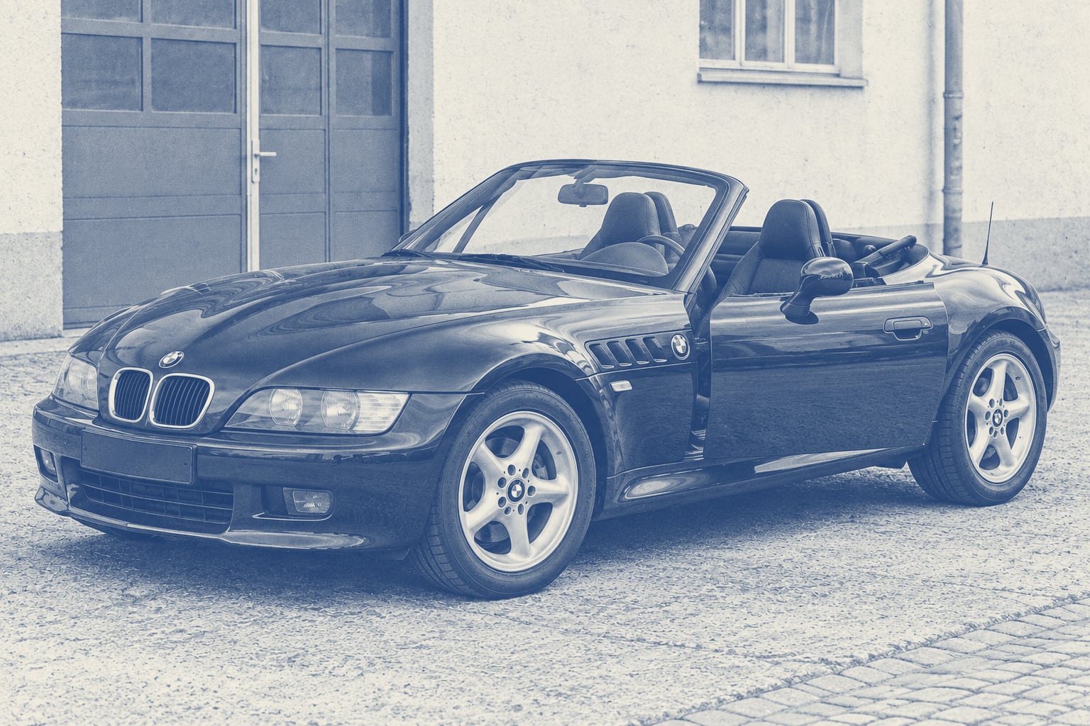 BMW Z3 Roadster mit leicht geöffneter Tür in einem einfachen Hof.