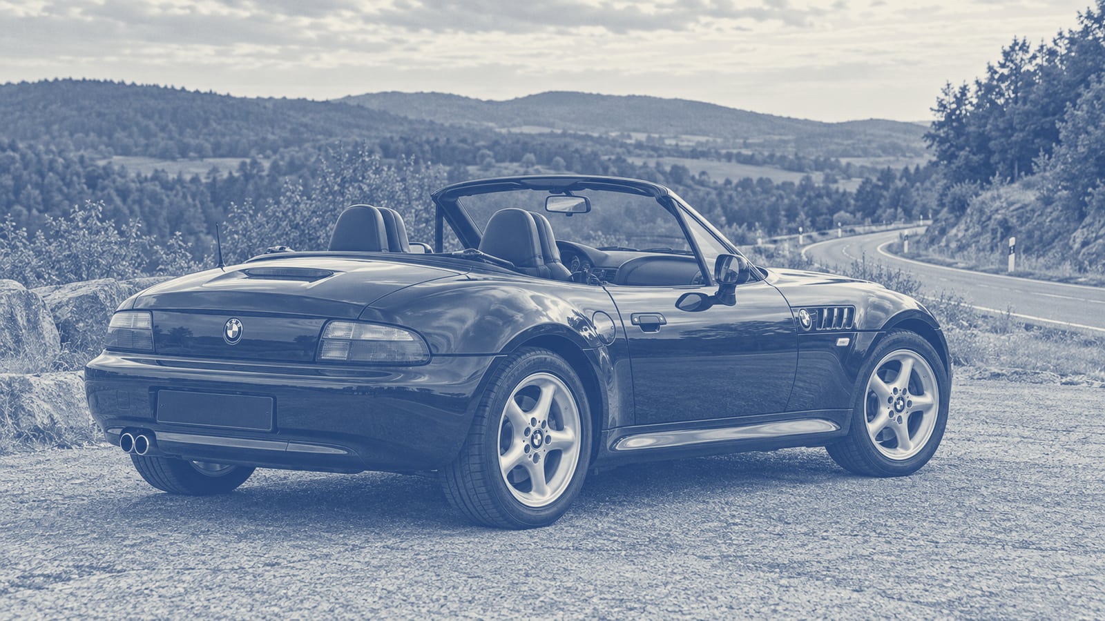 Z3 Roadster steht mit offenem Dach an einem breiten Halteplatz neben einer ruhigen Landstraße.